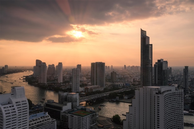 Cityscape of skyscraper with Chao Phraya river at sunset in Bangkok