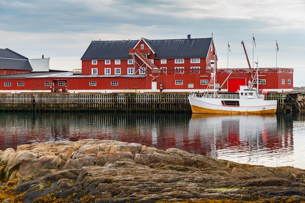 Cityscape of the town henningsvaer whaling and whaler boat rocky coast with dramatic sky classic