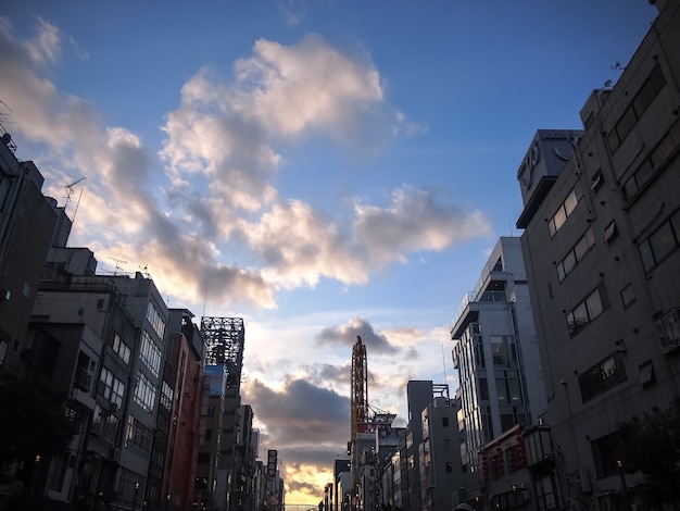 Cityscape with buildings at sunset against cloudy sky