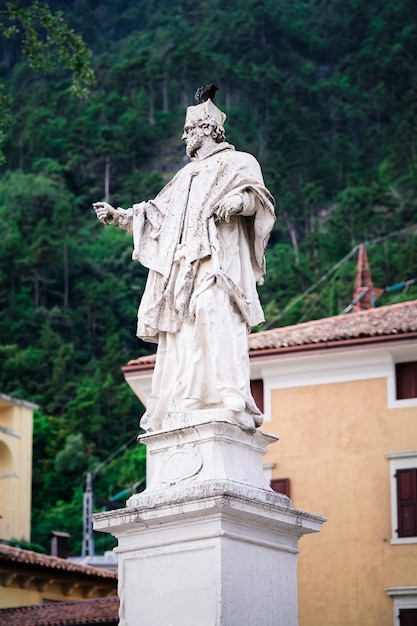 Cityscape with Religious sculpture in Arco town center near Garda lake of Trentino of Italy. Street and statue of Saint at Old city in Trento near Riva del Garda. Building architecture. Travel tourism