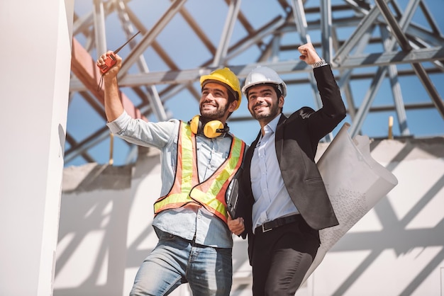 Civil engineer and construction architecture worker are working in construction site with tablet and blueprints for planing about new construction siteCooperation teamwork concept