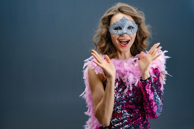 Clap one's hands enthusiastic young woman in a shining purple dress with a boa at the neck