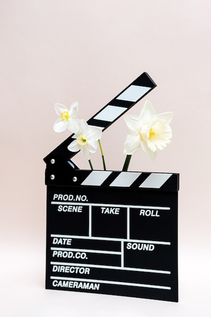 Clapper board for making video cinema and daffodils flower