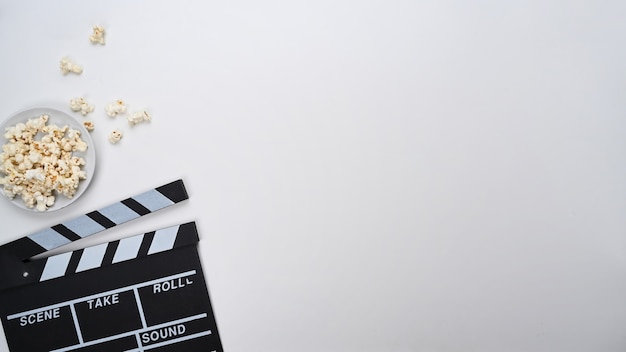 Clapperboard and popcorn isolated on white background. Copy space for your text.