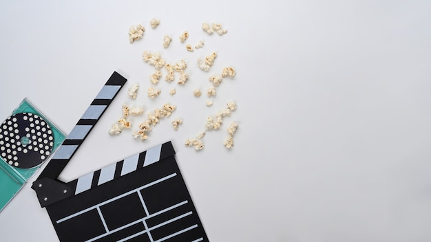 Clapperboard and popcorn on white background.