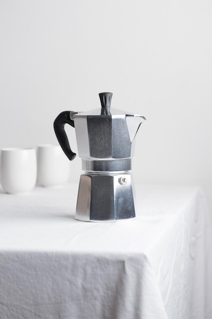 Classic aluminium coffee maker on white table