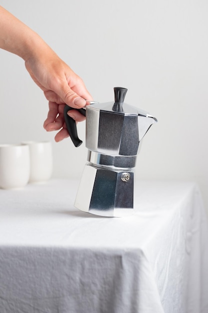 Classic aluminium coffee maker on white table