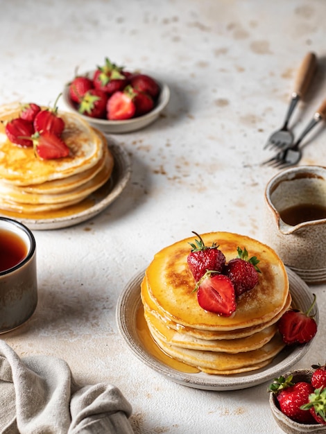 Classic american breakfast rustic style concept Homemade pancakes with strawberry and honey on kitchen table