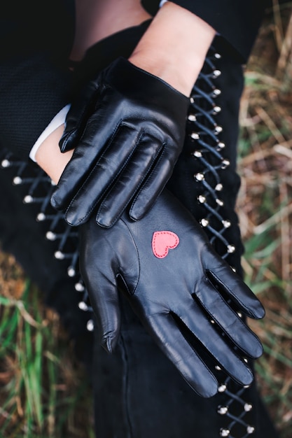 Classic black gloves with a heart in his palm on a female hand.