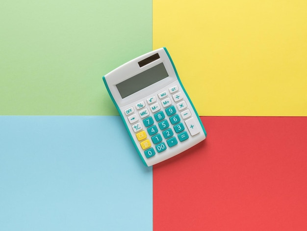 A classic calculator on a background of four colors. A device for computing. Minimal accounting concept.