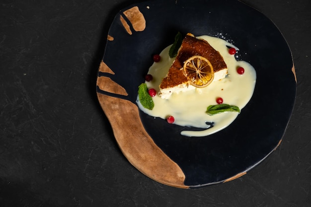 Classic cheesecake on a black background dessert on a black background in a black plate