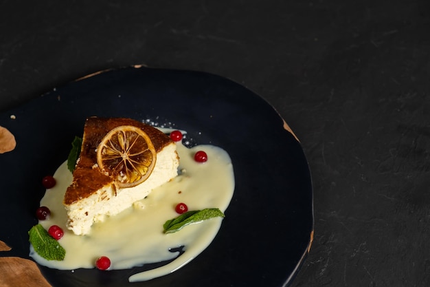 Classic cheesecake on a black background dessert on a black background in a black plate