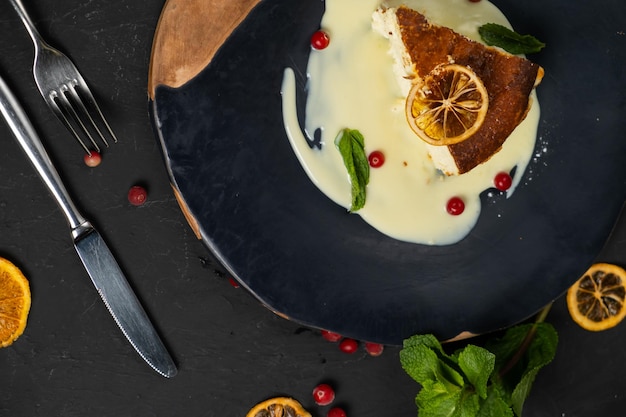 Classic cheesecake on a black background dessert on a black background in a black plate