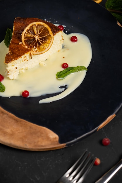 Classic cheesecake on a black background dessert on a black background in a black plate