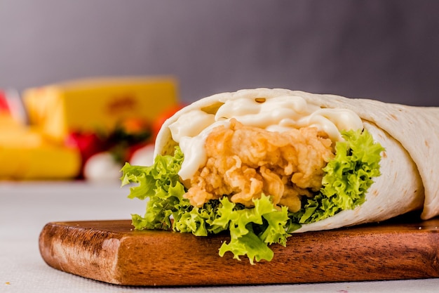 Classic Chicken Wrap Meal isolated on wooden board side view on grey background fastfood