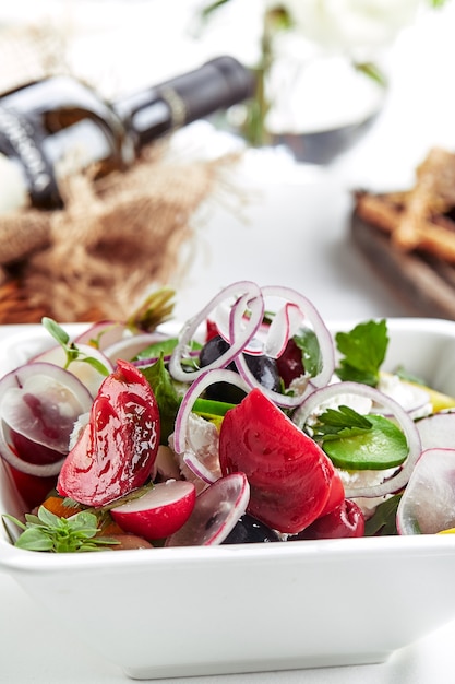 Classic Greek salad. Banquet festive dishes. Gourmet restaurant menu. White background.