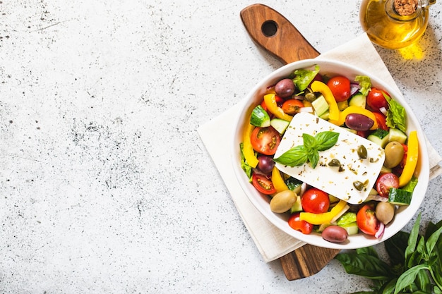 Classic Greek salad of fresh cucumber tomato sweet pepper lettuce red onion feta cheese and olives with olive oil