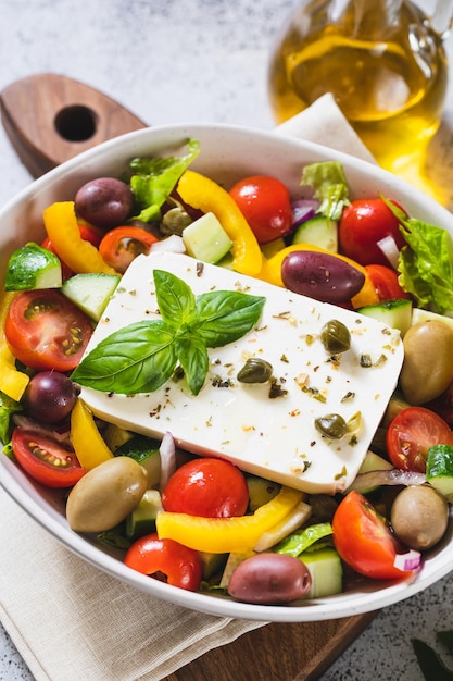 Classic Greek salad of fresh cucumber tomato sweet pepper lettuce red onion feta cheese and olives with olive oil