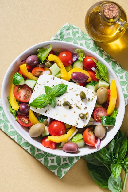 Classic Greek salad of fresh cucumber tomato sweet pepper lettuce red onion feta cheese and olives with olive oil