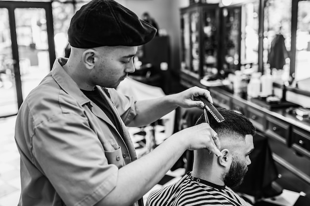 Classic haircut in a barbershop. Curve hair styling and hair health care in a barbershop. Men's haircut.