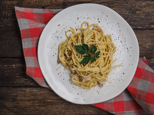 Classic hoemade pasta carbonara spaghetti with bacon egg yolk parsley and parmesan cheese on light p