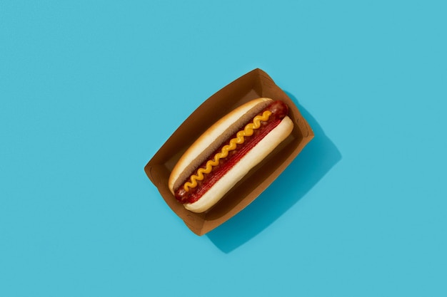 Classic hot dog with wurst ketchup and mustard on blue background Restaurant menu delivery tacke away concept