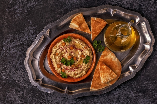 Classic hummus with parsley on the plate and pita bread