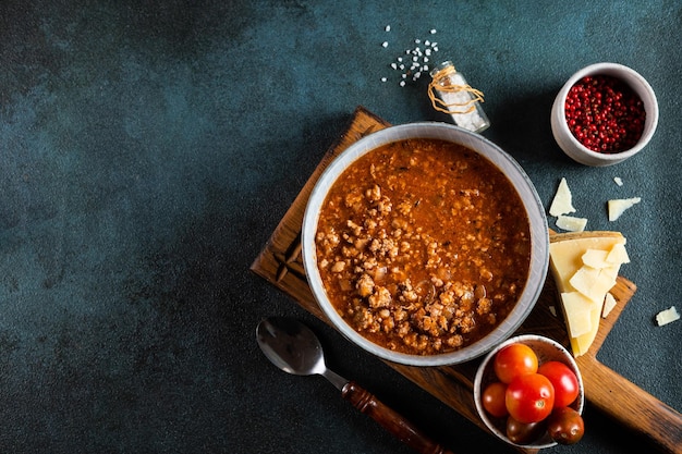 Classic italian bolognese sauce with ingredients on blue background Bolognese sauce top view culinary background with space for text Pasta bolognese Italian lasagna