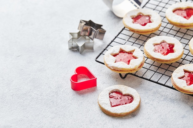 Classic linzer christmas cookies with raspberry or strawberry jam on light background