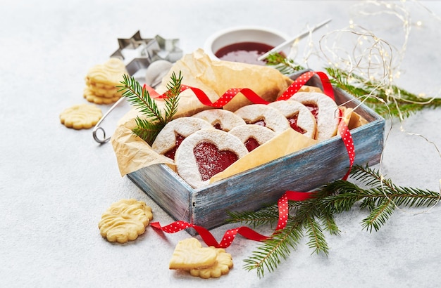 Classic linzer christmas cookies with raspberry or strawberry jam on light background