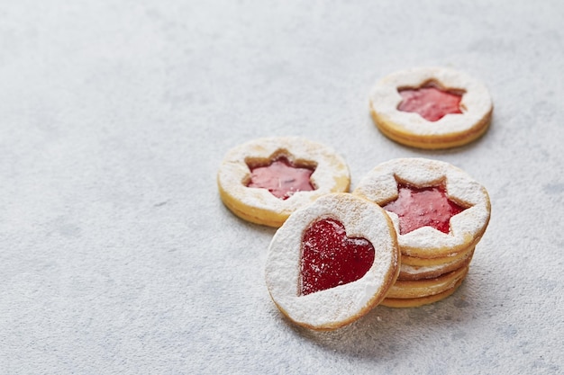 Classic linzer christmas cookies with raspberry or strawberry jam on light background