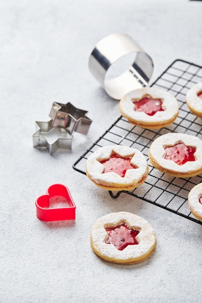 Classic linzer christmas cookies with raspberry or strawberry jam on light background