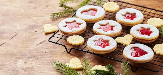 Classic linzer christmas cookies with raspberry or strawberry jam on wooden table