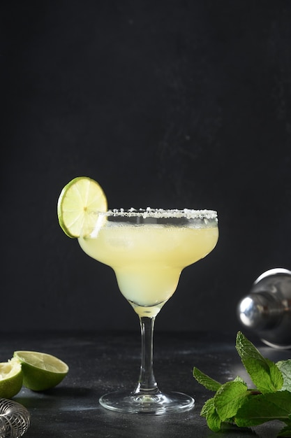 Classic margarita cocktail with lime and ice cube on black background freshness summer alcoholic