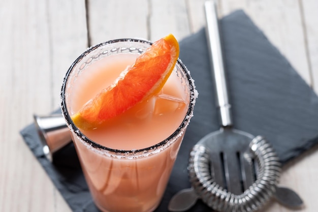 Classic paloma cocktail on white wooden table