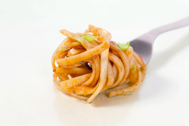 Classic pasta with tomato sauce on fork.