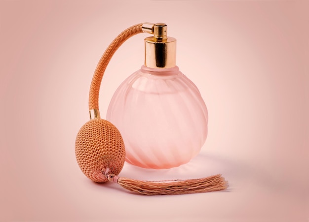 Classic perfume spray bottle with tassel in pink studio