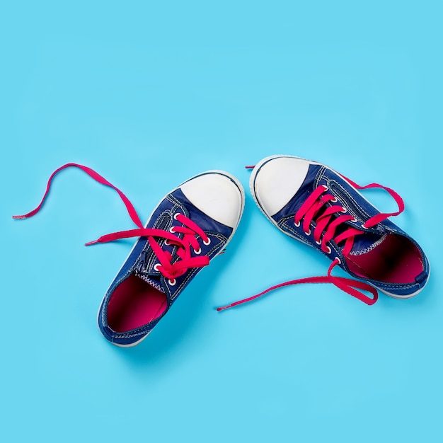 Classic sneakers over light blue background, above view. Image with space for text or other design