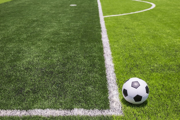 Classic soccer ball on artificial bright and dark green grass