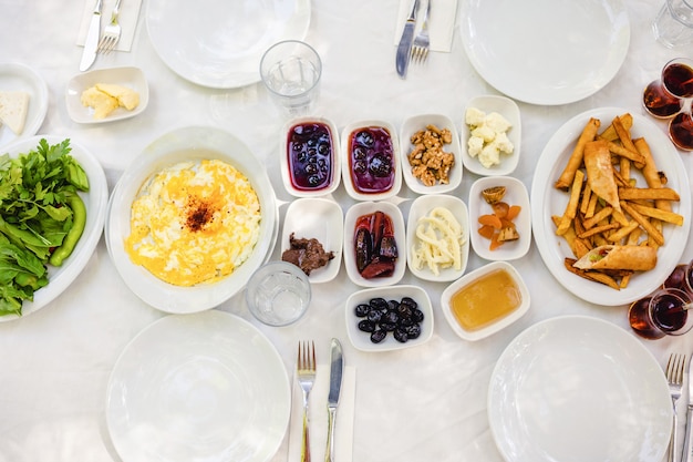 Classic Turkish breakfast - omelet, cottage cheese, jam, honey, nuts, fried potatoes, herbs, tea.