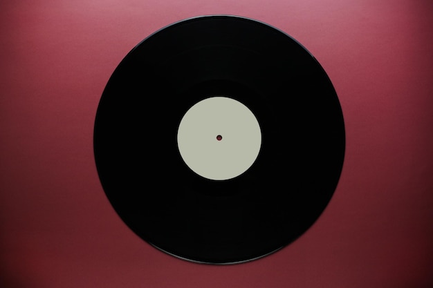 Classic vinyl record closeup on a red burgundy background outdated data storage music