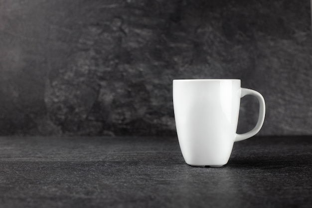 Classic white mug on dark concrete stone