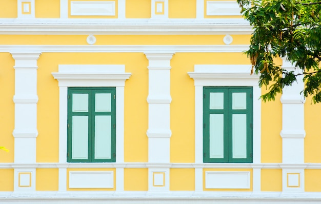 Classic wood window at the yellow concrete building