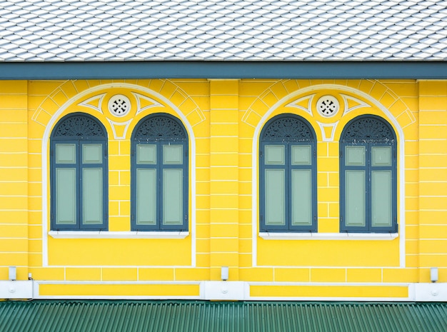 Classic wood window at yellow concrete building