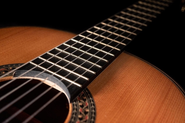 Classical guitar on black background Acoustic guitar conceptPerfect for flyer card poster or wallpaper