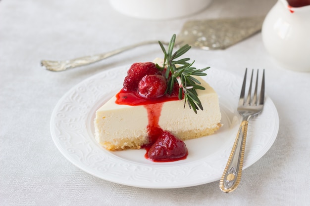 Classical New York cheesecake with strawberry sauce and rosemary