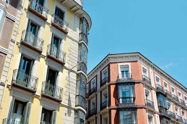 Classical yellow red buildings with elegant metallic balconies Chueca district downtown Madrid Spain