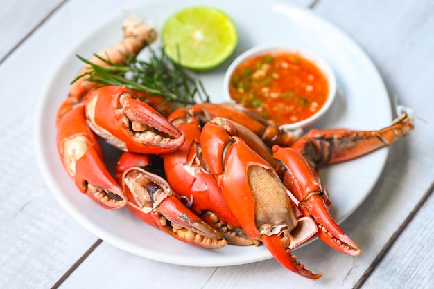 Claw crab cooking food seafood plate with chili herbs spices lemon lime salad fresh crab on white plate seafood sauce boiled or steamed crab red in the restaurant