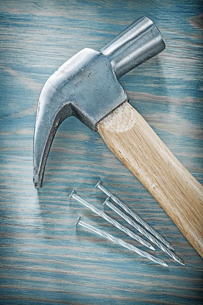 Claw hammer stainless nails on wooden board top view construction concept