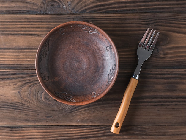 Clay bowl on a brown wooden table.